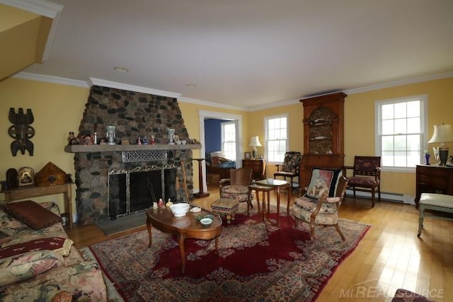 living room with a fireplace, ornamental molding, light hardwood / wood-style flooring, and a wealth of natural light