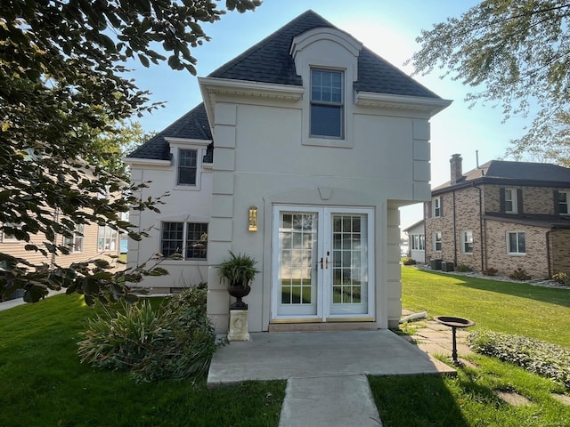 rear view of house featuring french doors, a lawn, and central AC