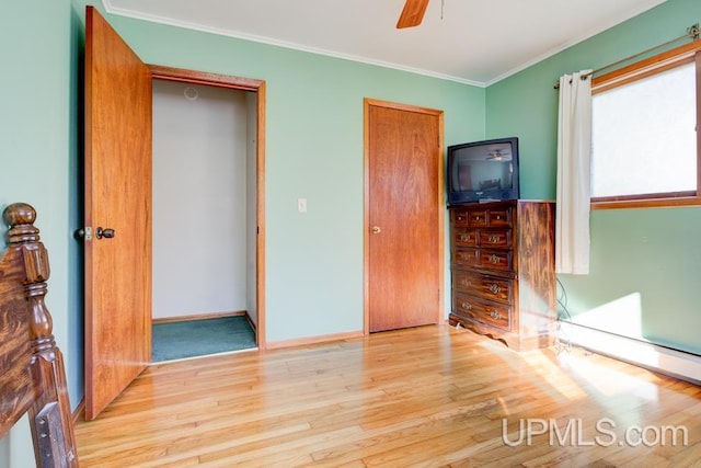 unfurnished bedroom with ceiling fan, light wood-type flooring, and ornamental molding