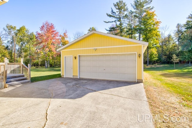 garage with a yard and wood walls