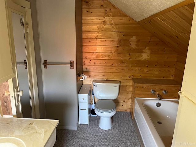 bathroom featuring vanity, wood walls, lofted ceiling, toilet, and a tub to relax in