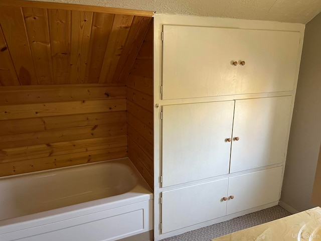 bathroom featuring wood ceiling and a tub to relax in