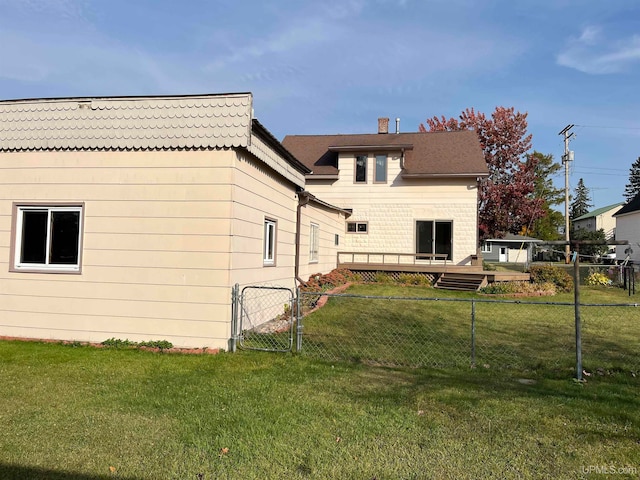 back of house with a wooden deck and a yard