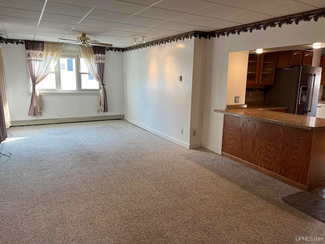 kitchen featuring kitchen peninsula, high end refrigerator, baseboard heating, ceiling fan, and carpet floors