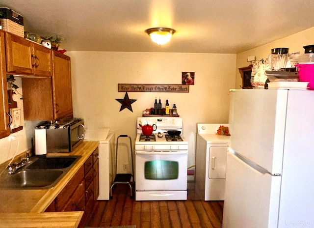 kitchen with dark hardwood / wood-style floors, sink, white appliances, and washer / dryer