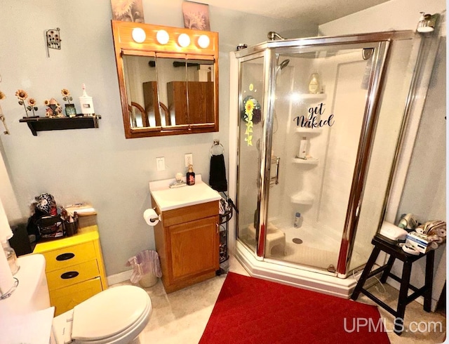 bathroom featuring walk in shower, vanity, and toilet