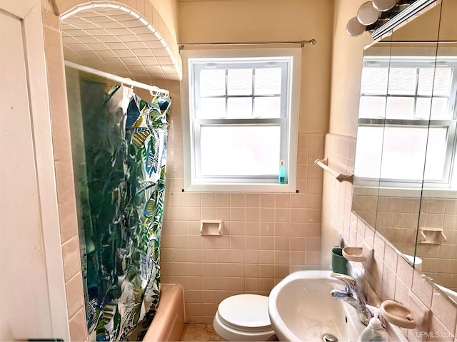 full bathroom featuring shower / bath combination with curtain, tile walls, sink, and toilet