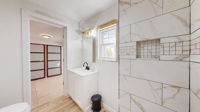 bathroom with hardwood / wood-style flooring, toilet, and vanity