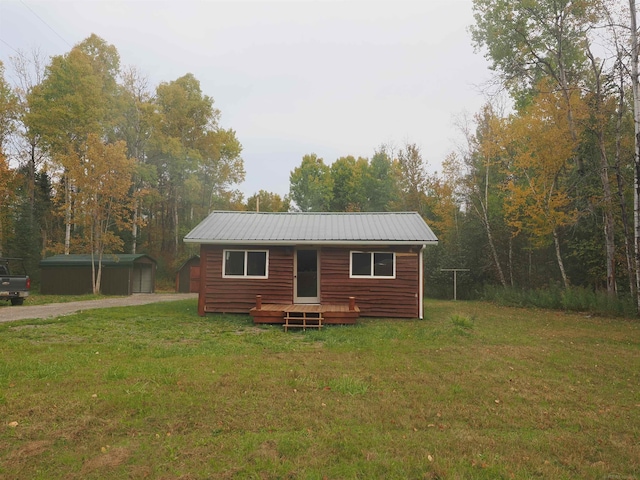 log cabin with a front lawn and a storage unit