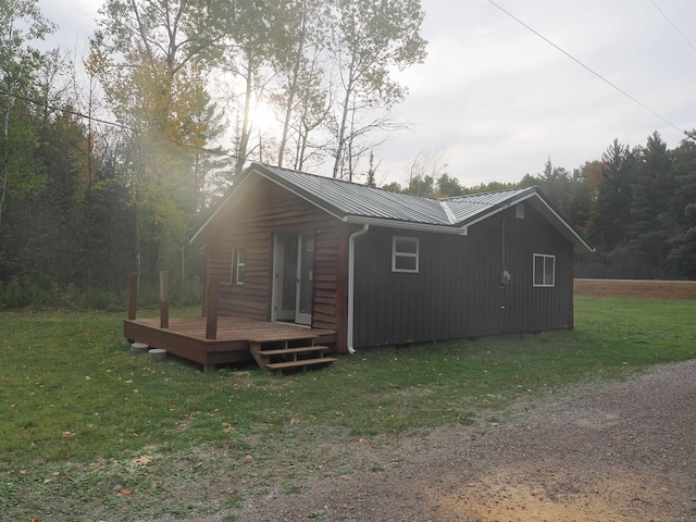 exterior space featuring a wooden deck and a lawn