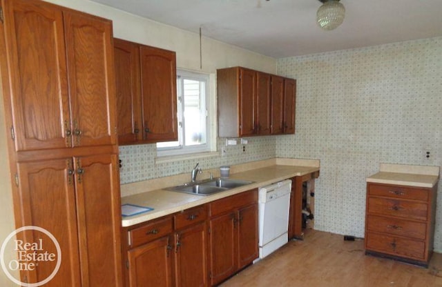 kitchen with white dishwasher, light hardwood / wood-style flooring, and sink