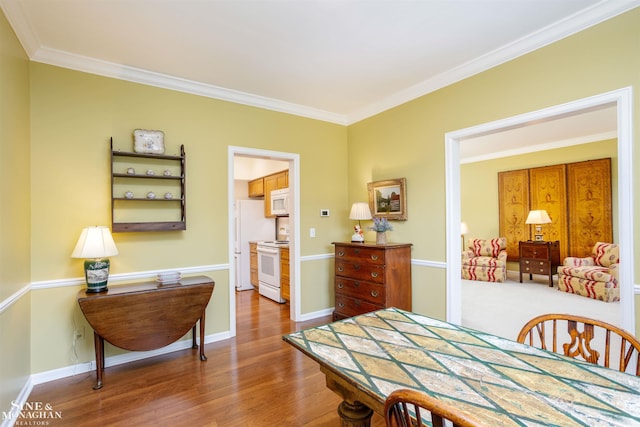 dining space with crown molding and hardwood / wood-style flooring