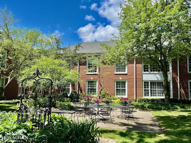 back of house with a lawn and a patio