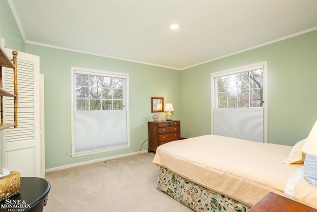 bedroom with ornamental molding, multiple windows, and light colored carpet