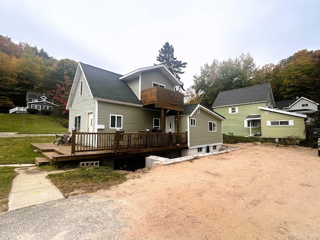 view of front facade with a front lawn and a deck