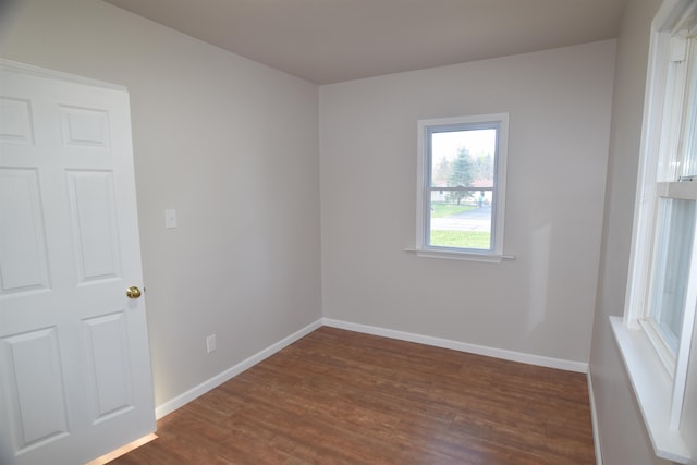 empty room with dark hardwood / wood-style flooring