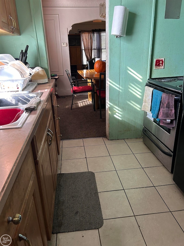 kitchen with black electric range and light tile patterned floors