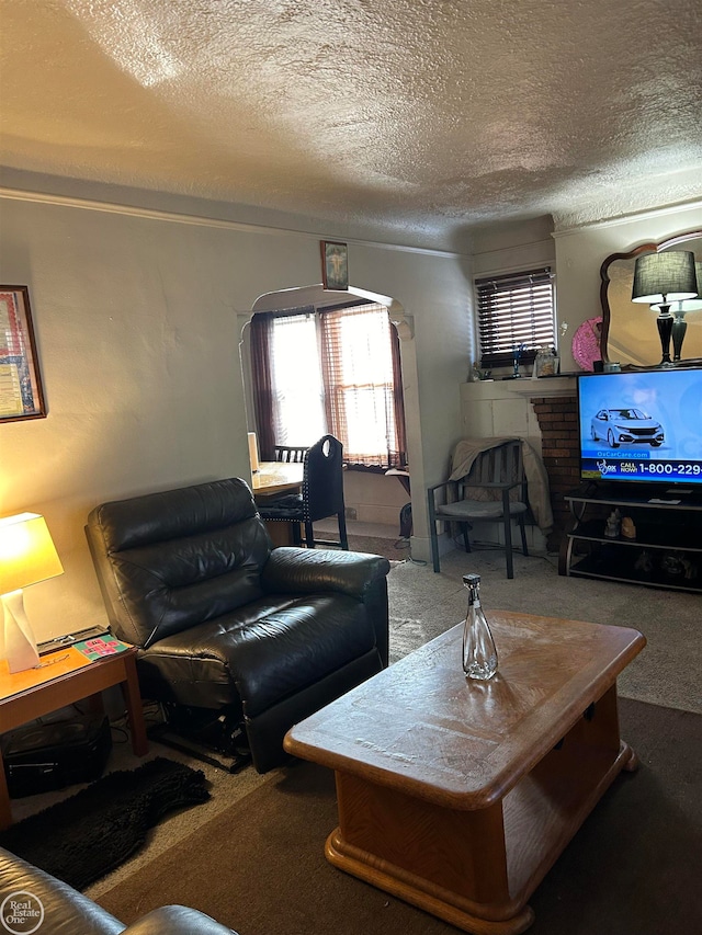 living room with a fireplace, a textured ceiling, and carpet floors