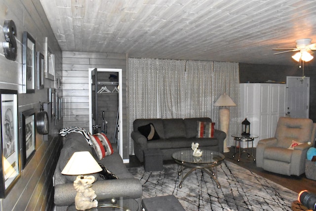 living room featuring wooden walls and ceiling fan