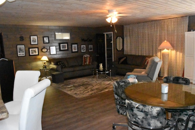 living room with dark wood-type flooring, wooden ceiling, and ceiling fan