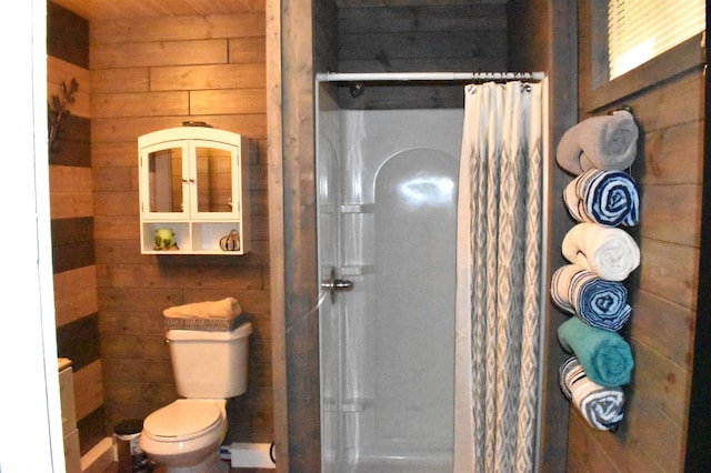 bathroom with wood walls, toilet, and curtained shower