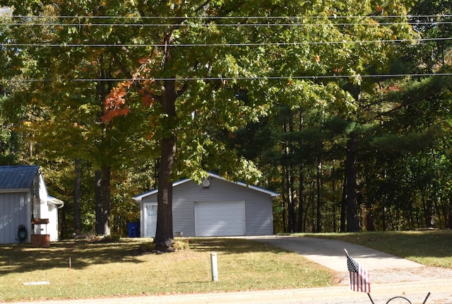 exterior space featuring a garage, an outdoor structure, and a front lawn