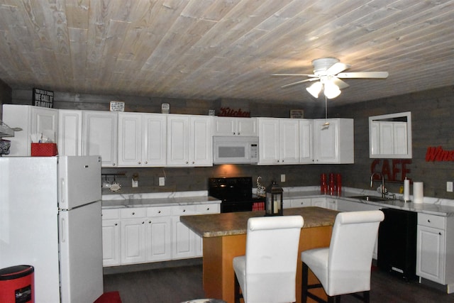 kitchen featuring black appliances, a center island, sink, and white cabinets