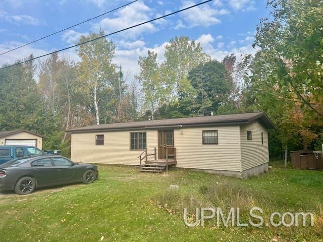 manufactured / mobile home featuring a front yard and an outbuilding