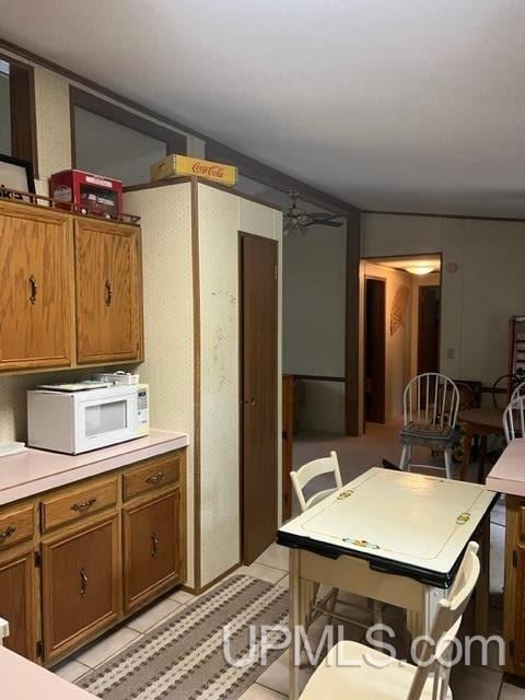 kitchen with light tile patterned flooring and vaulted ceiling