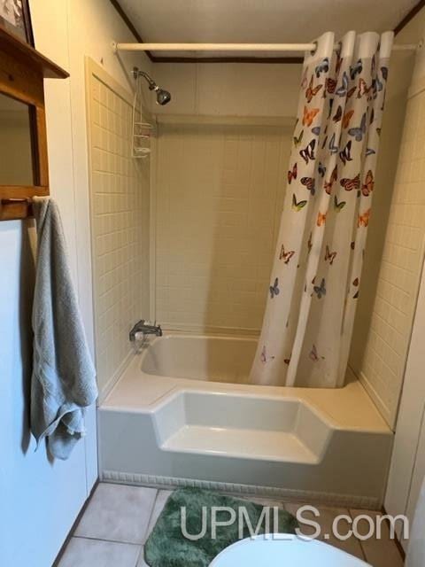 bathroom featuring toilet, tile patterned flooring, and shower / bath combo