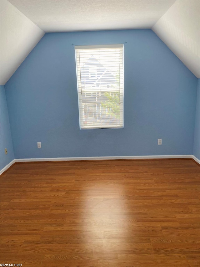 bonus room with lofted ceiling and hardwood / wood-style floors