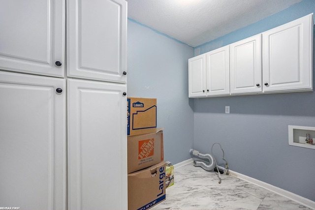 clothes washing area featuring washer hookup, a textured ceiling, and cabinets