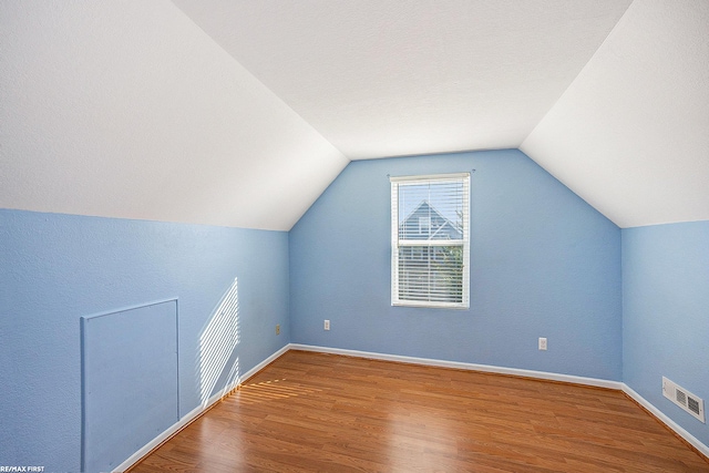 additional living space with lofted ceiling and wood-type flooring