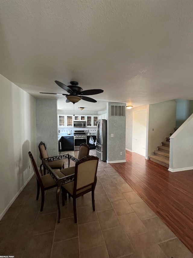 dining area featuring a textured ceiling, hardwood / wood-style flooring, built in features, and ceiling fan