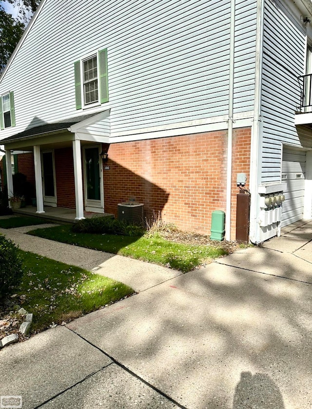 view of side of home with central air condition unit and a garage