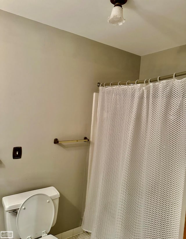 bathroom featuring toilet and a shower with shower curtain