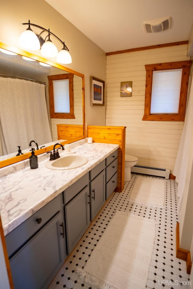 bathroom featuring tile patterned floors, toilet, vanity, and a baseboard radiator