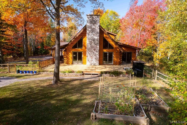 back of property featuring a wooden deck and a yard