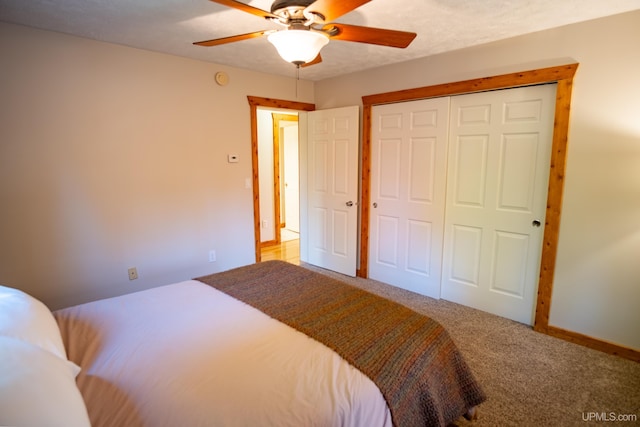 bedroom featuring a textured ceiling, ceiling fan, a closet, and carpet flooring