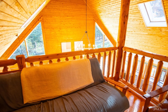 interior space with high vaulted ceiling, a wealth of natural light, wood-type flooring, and wooden walls