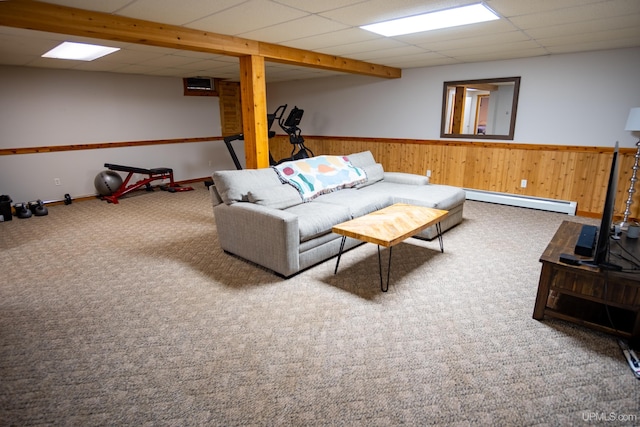 carpeted living room with a drop ceiling, wood walls, and baseboard heating