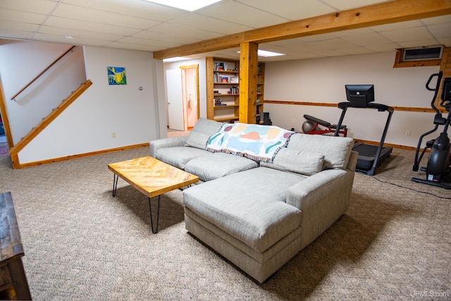 living room featuring carpet floors and a drop ceiling