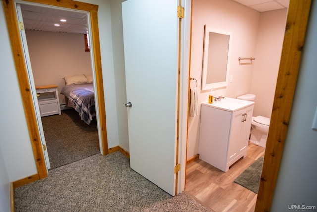 hallway with light colored carpet and sink