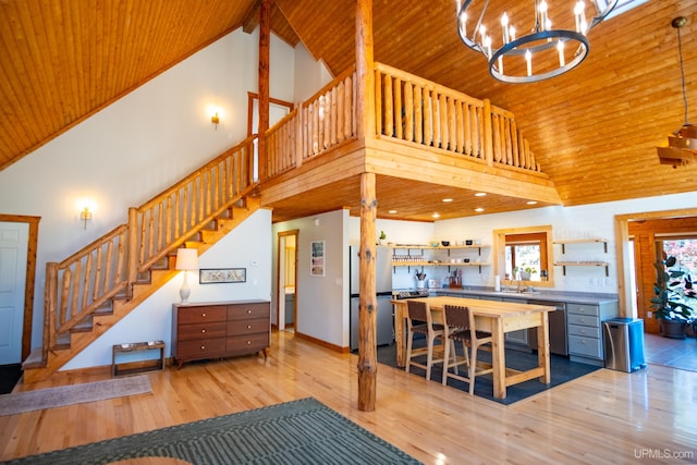 living room with high vaulted ceiling, wood ceiling, and light hardwood / wood-style flooring