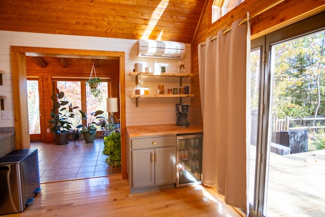 interior space featuring plenty of natural light, light hardwood / wood-style floors, wooden ceiling, and a wall unit AC