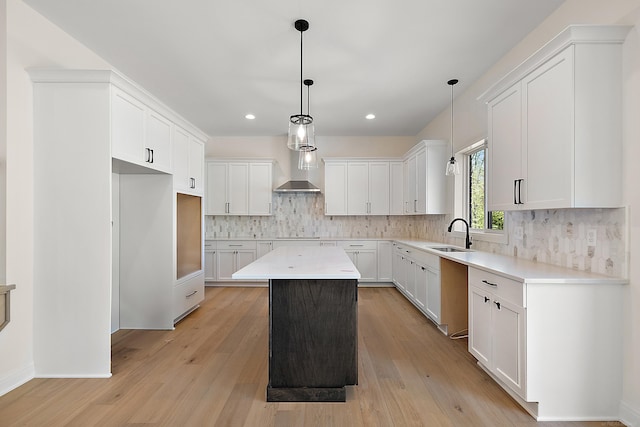 kitchen with light hardwood / wood-style flooring, hanging light fixtures, white cabinetry, and a center island