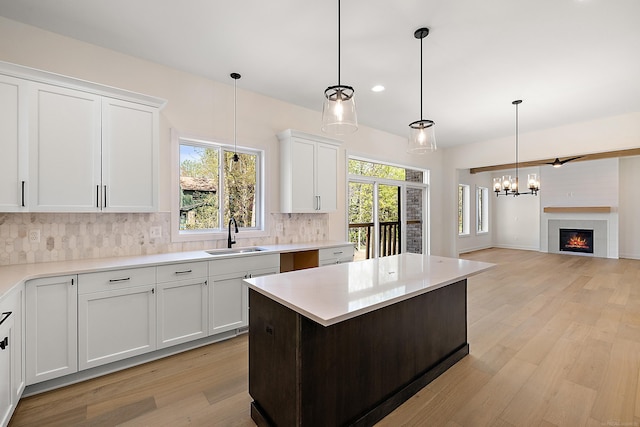 kitchen featuring white cabinets, pendant lighting, light hardwood / wood-style floors, and tasteful backsplash