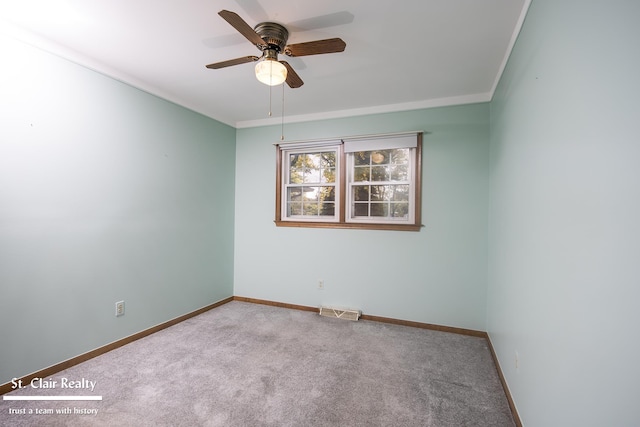 spare room featuring light carpet, ornamental molding, and ceiling fan