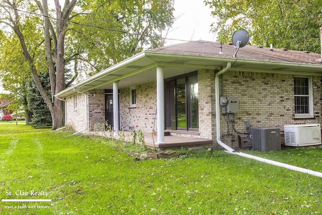 exterior space with central AC and a front yard