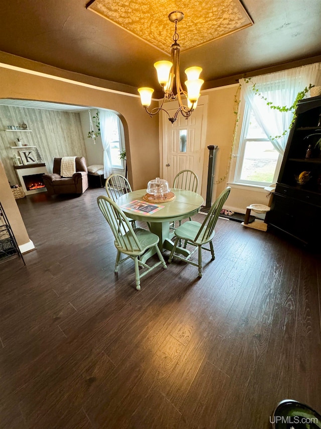 unfurnished dining area with a notable chandelier and dark wood-type flooring